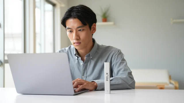 ノートパソコンに向かう就活生と電子タバコデバイスのイメージ